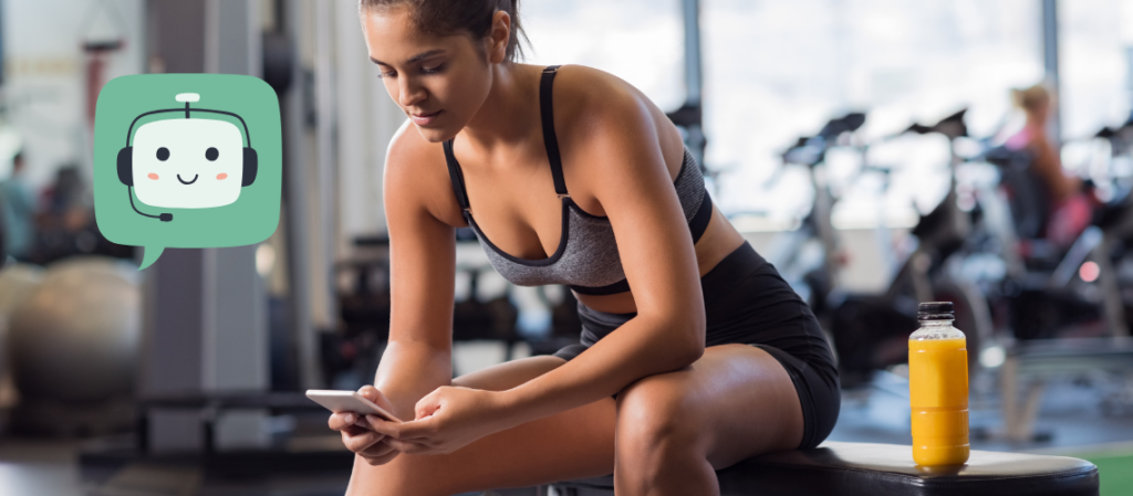 kobieta w klubie fitness sprawdza na telefonie swój trening